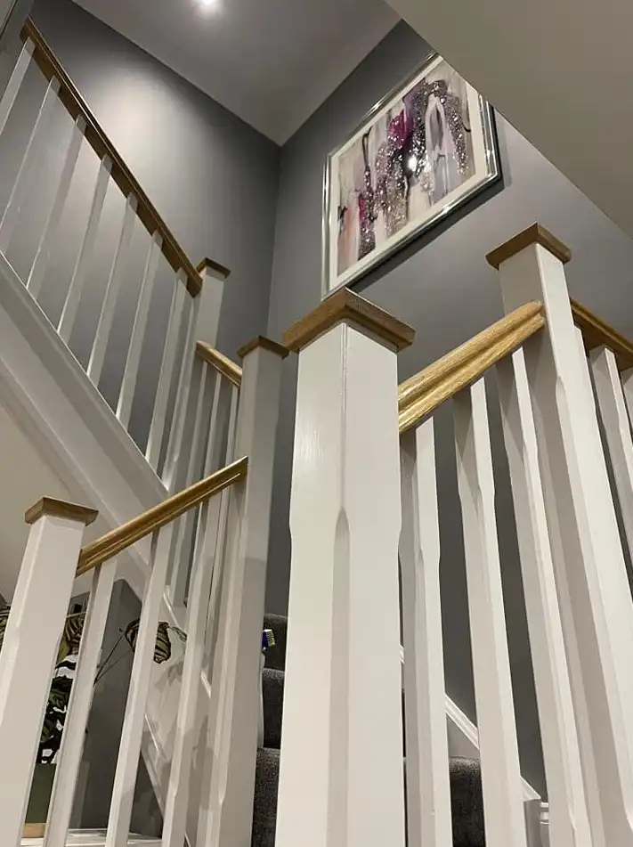 Feature staircase decorating with painted spindles and timber handrail in Devon by Fineline Decorators Plymouth